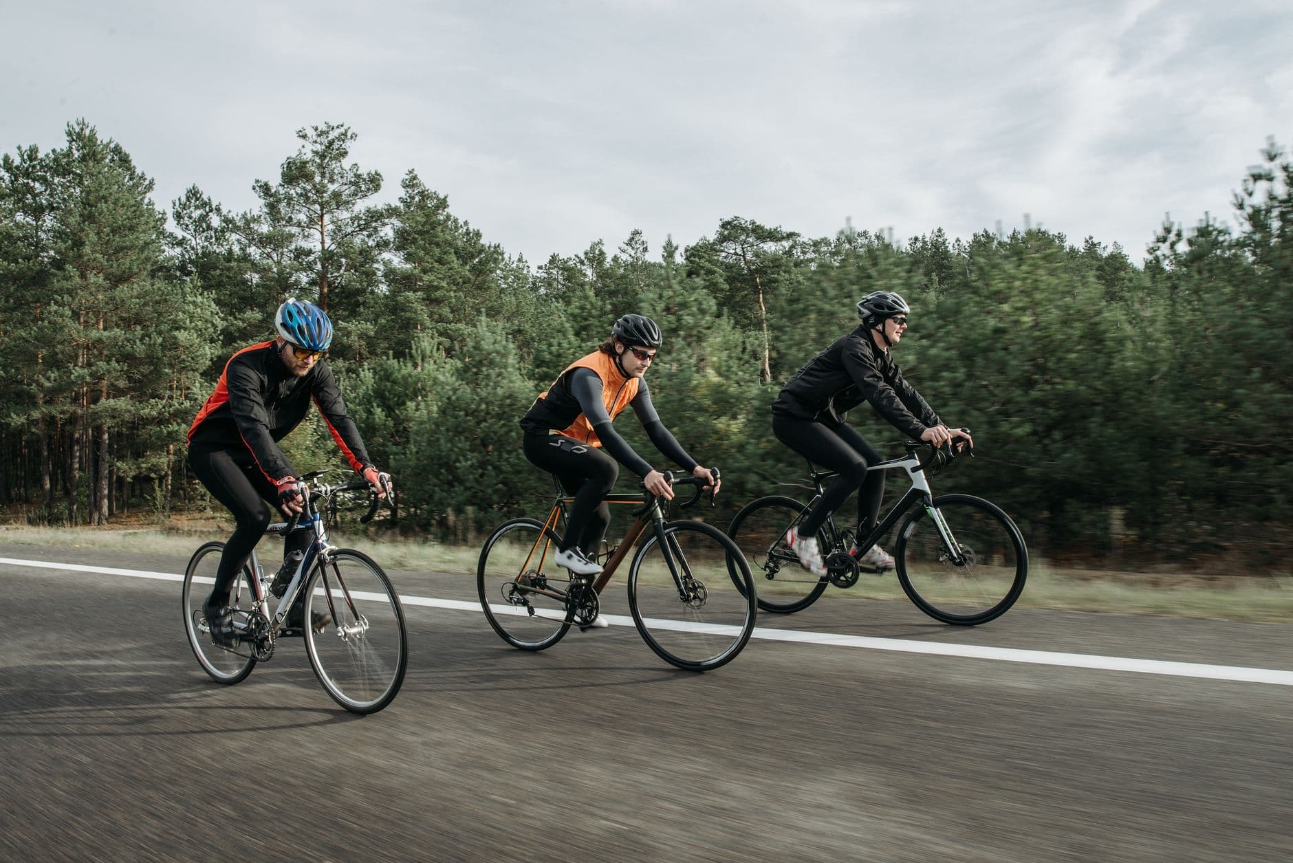 Grupo de ciclistas circulando en fila por una carretera