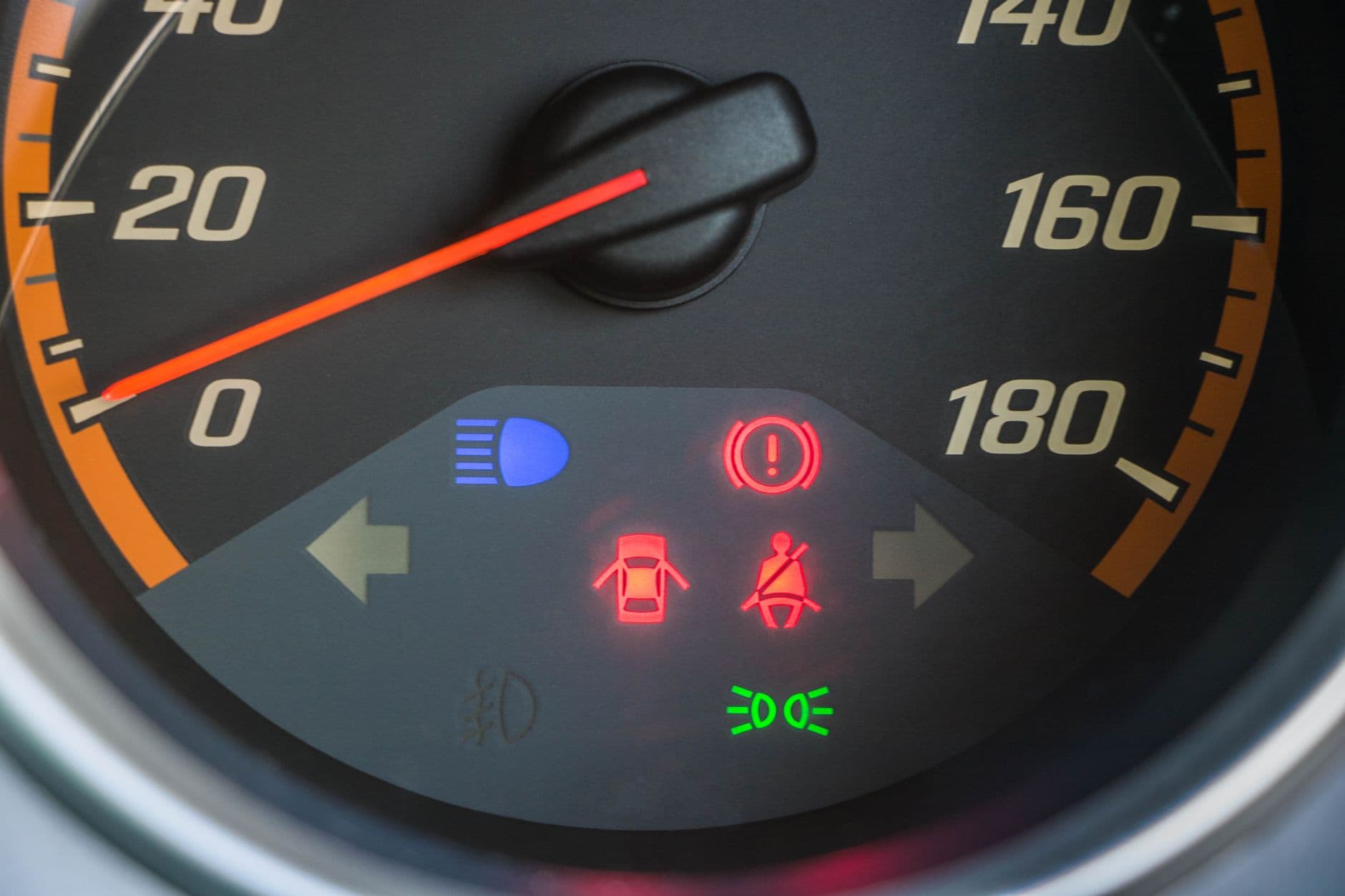 Cuadro de mandos de un coche con el cuentakilometros y un testigo encendido