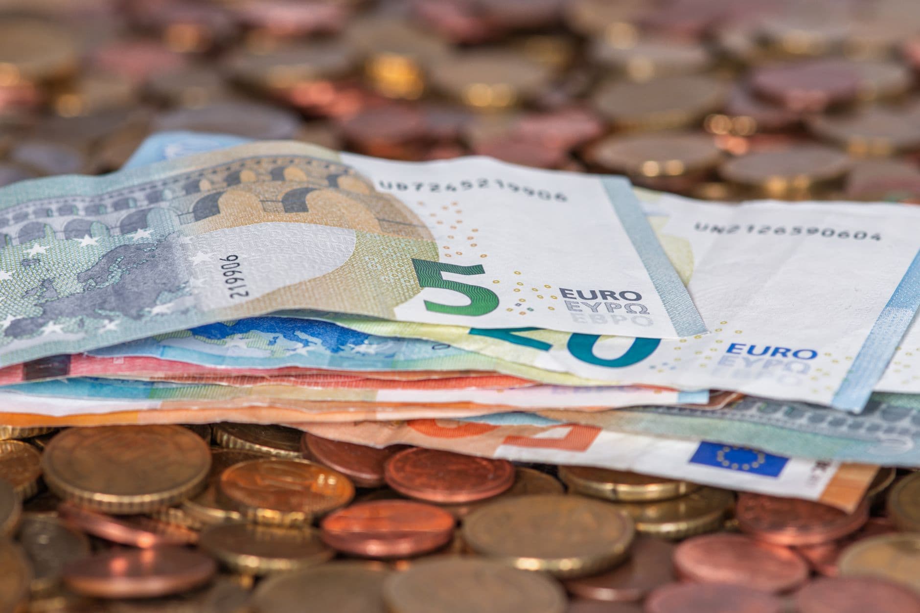 Billetes y monedas de euro amontonados sobre una mesa