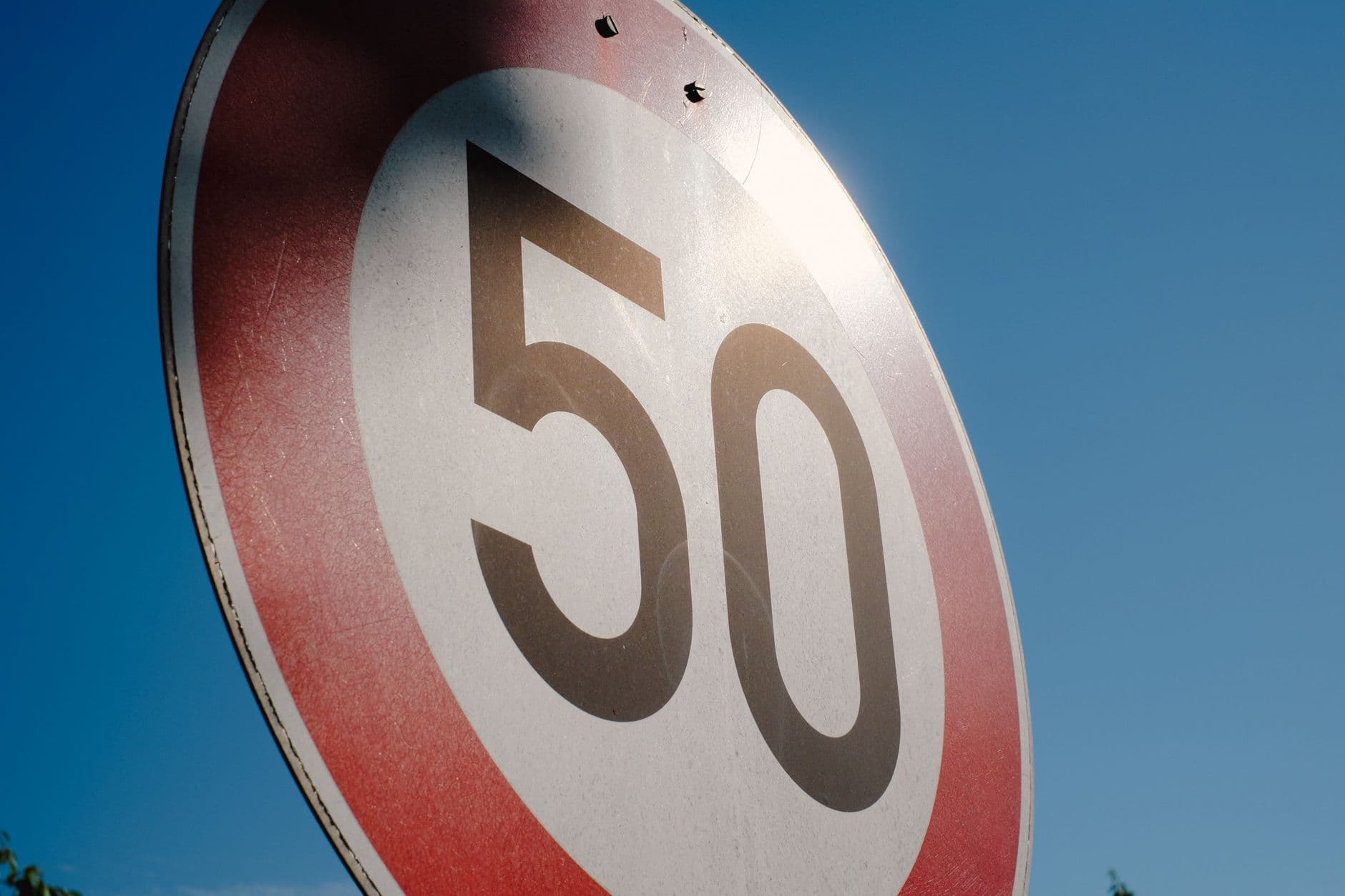 Senal circular de limite de velocidad a 50 recortada contra el cielo