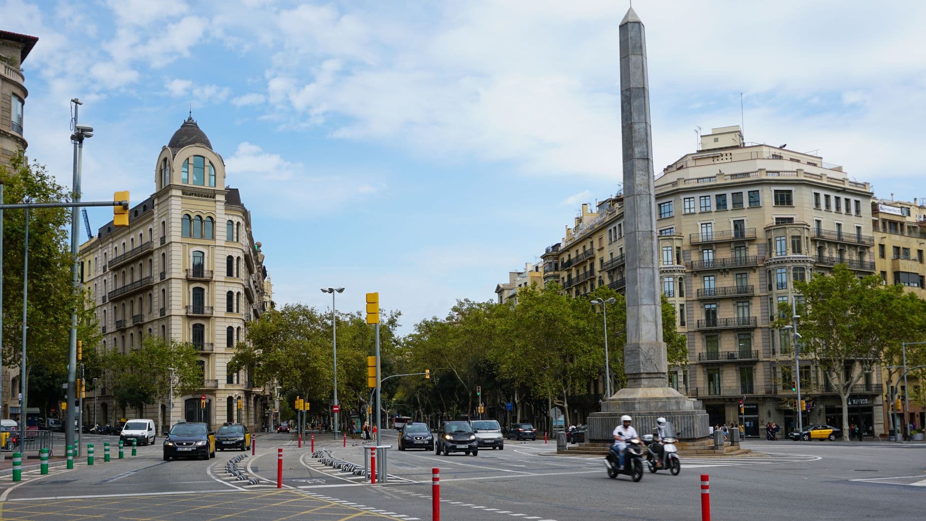 Coches y motos circulando por una avenida ancha del centro de Barcelona